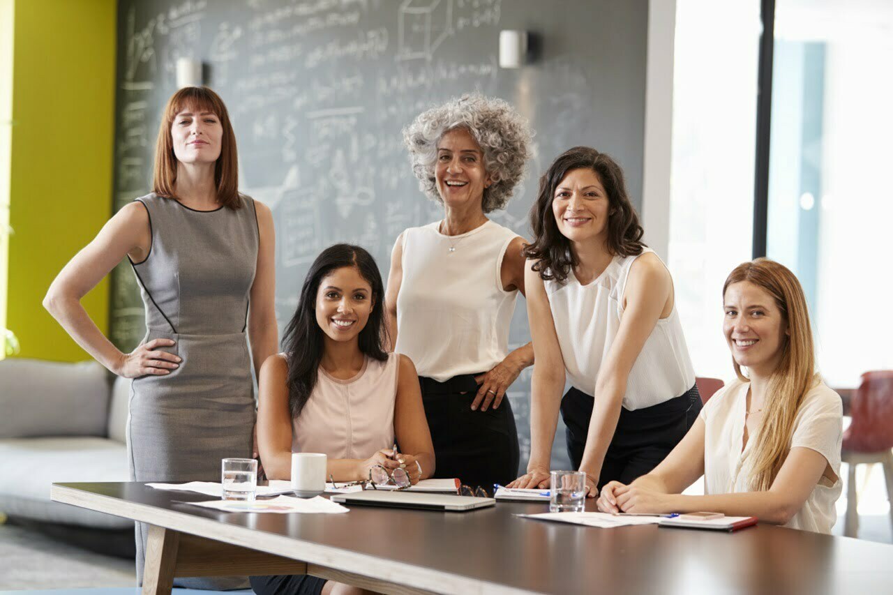 stock-photo-five-female-colleagues-at-a-work-meeting-smiling-to-camera-749253997